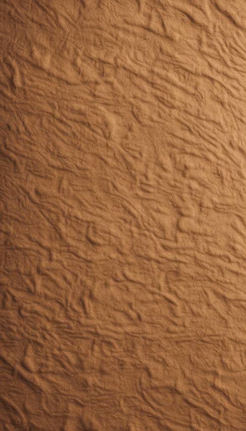 Un primer plano de la textura de cuero de gamuza color canela bajo una iluminación suave.