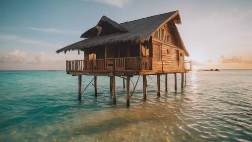 A cabin resting on stilts above crystal-clear tropical waters during the golden hour.