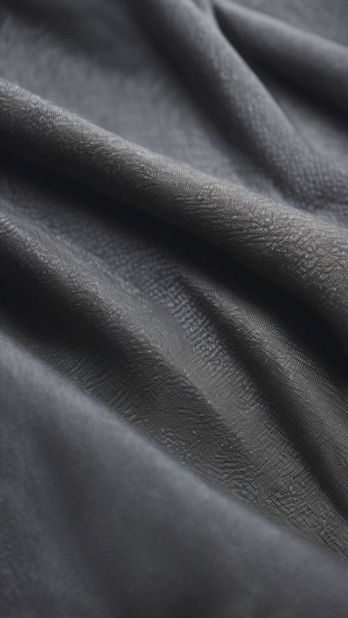 Close up of a dark gray textured fabric against natural light.