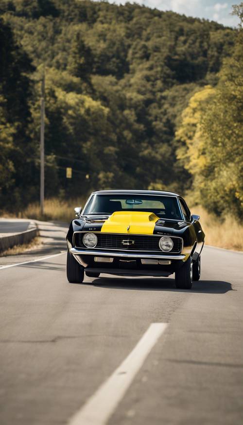 A 1967 black and yellow Chevrolet Camaro speeding down a highway.