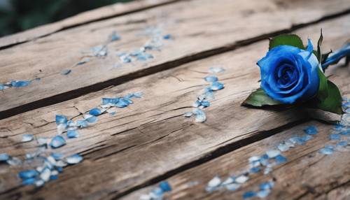 Meja kayu lapuk yang dihiasi dengan bunga mawar biru di tengahnya.