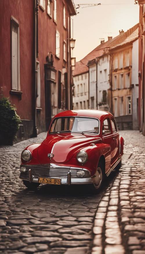 Um carro vermelho antigo estacionado em uma rua de paralelepípedos à luz da noite.