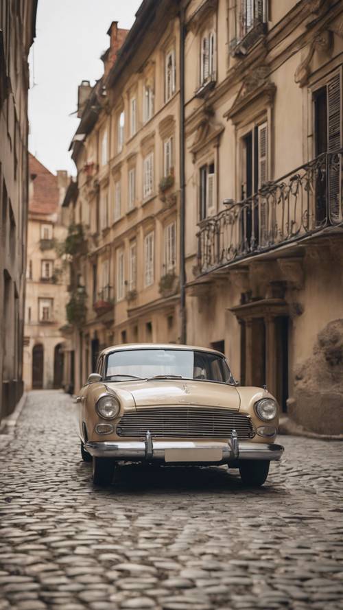 Un&#39;auto classica beige parcheggiata su una strada acciottolata con edifici rustici sullo sfondo.