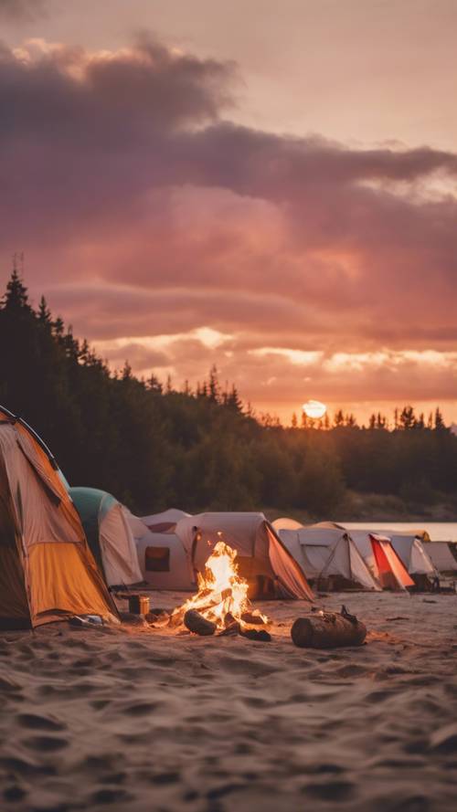 A vibrant sunset over a tranquil camping site set on a beach. A few tents are pitched, a fire is crackling, and a couple is roasting marshmallows.