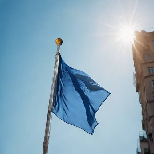 Eine flatternde blaue Seidenflagge vor einem klaren Himmel.