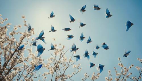 قطيع من الطيور الزرقاء يندفع عبر السماء الزرقاء النابضة بالحياة في يوم مشمس.