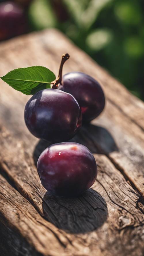A close up of a juicy ripe plum resting on a rustic wooden table.