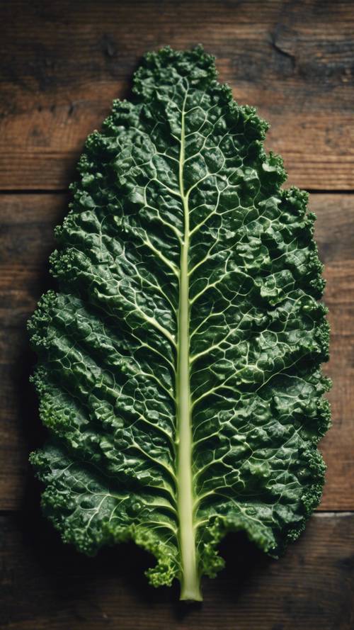 A perfectly symmetrical kale leaf, richly green and hearty, placed on a rustic tabletop.
