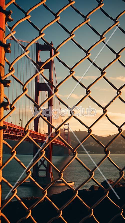 日落時穿過柵欄的金門大橋