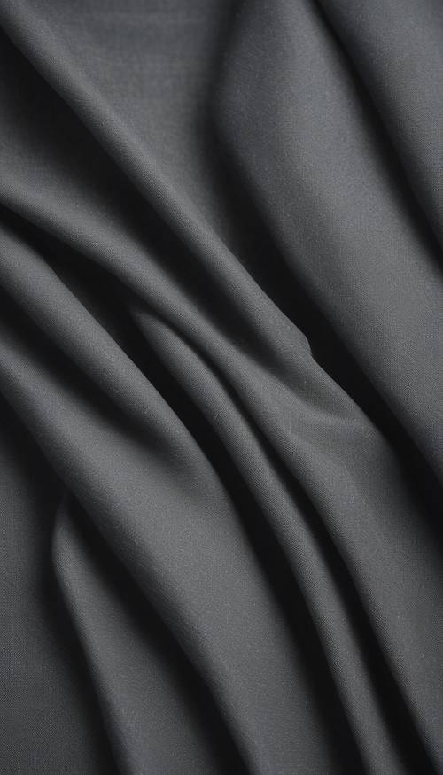 Uma folha de tecido cinza escuro com textura uniforme e sem estampas.