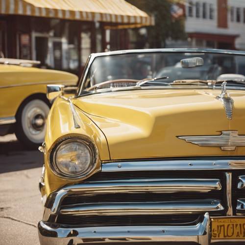 Un descapotable amarillo vintage con adornos dorados, estacionado junto a un restaurante clásico.