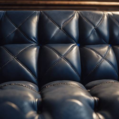 A close-up of navy blue, quilted leather upholstery on an antique chair.