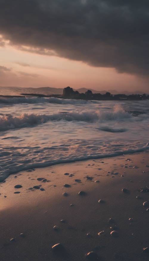 Una escena de playa al atardecer con un cielo negro y sombrío.