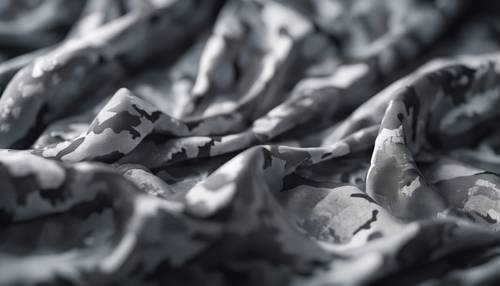 Grey camouflage textile draped under bright light