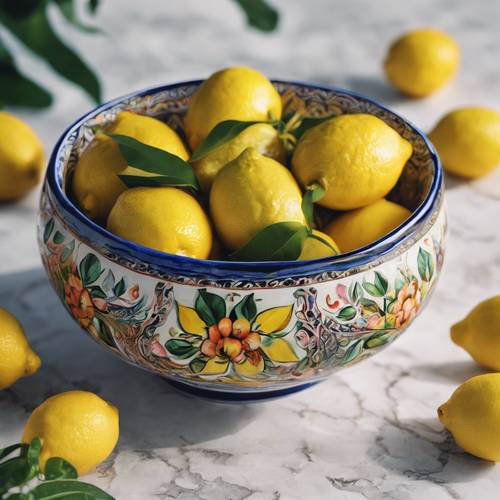 An ornate hand-painted ceramic bowl filled with vibrant, freshly picked lemons.
