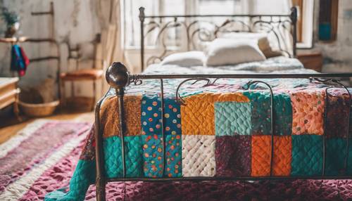 Eine mehrfarbige Steppdecke mit Punkten auf einem schmiedeeisernen Bett in einem Zimmer mit Boho-Dekor.