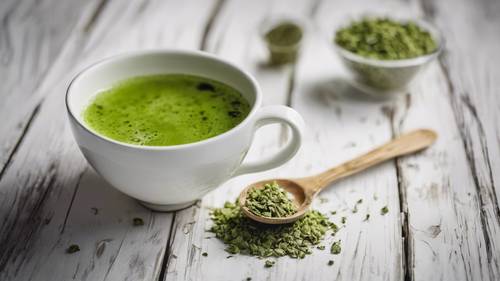 Secangkir teh hijau matcha di meja kayu putih pedesaan.
