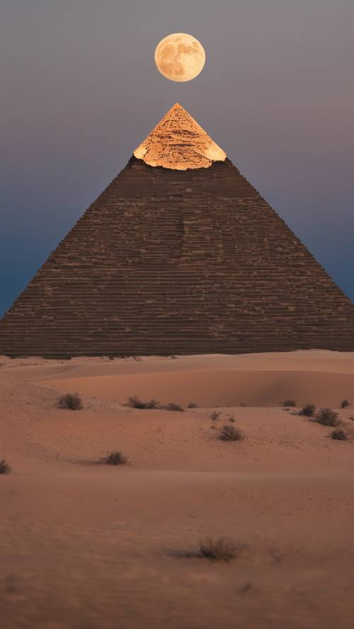 A pyramid under a full moon at midnight with radiant moonlight illuminating the desert landscape.