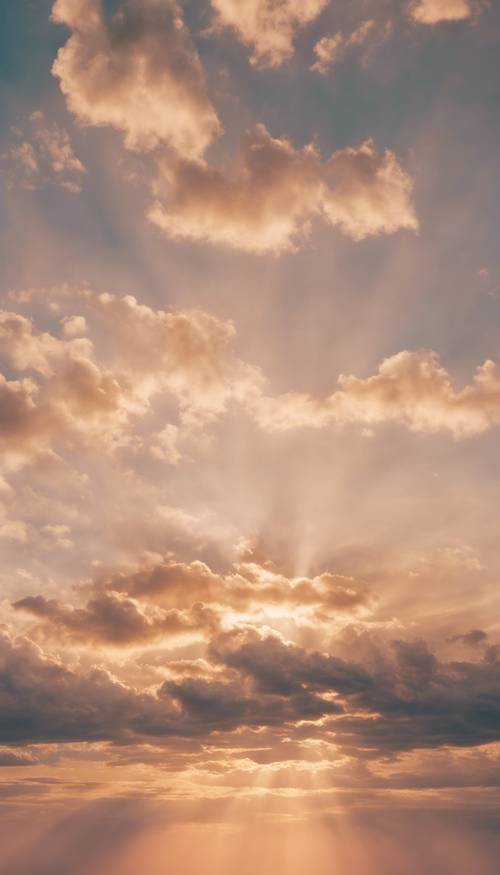 Jasnozłote marzycielskie chmury na pastelowym niebie o zachodzie słońca.