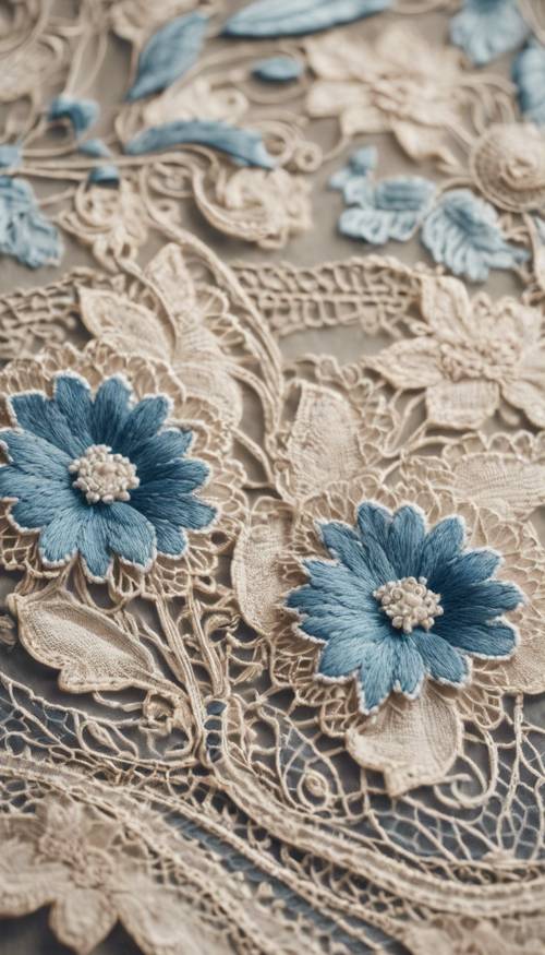 Zbliżenie na beżową koronkę w stylu vintage z delikatnym niebieskim kwiatowym haftem.