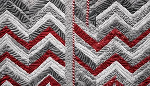 A quilt of mottled red and gray chevron stripes repeating in an infinite pattern.