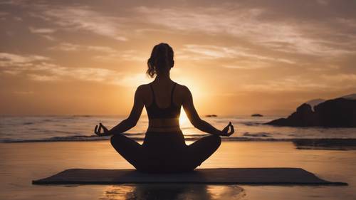 Ein leuchtender Sonnenuntergang mit der Silhouette einer Frau, die im Vordergrund Yoga macht.
