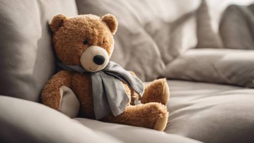 Rahat bir kanepede yastığa dayalı oturan bir oyuncak ayı.