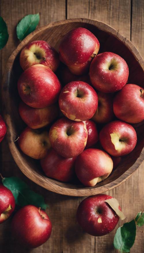 טבע דומם של תפוחים אדומים בשלים מסודרים בקערת עץ כפרית.