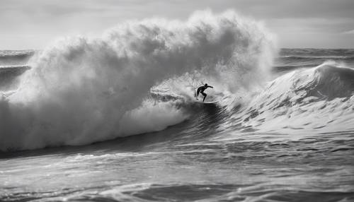 An interesting image of a surfer riding a monstrous wave, black and white emphasizing the drama and power of the ocean.