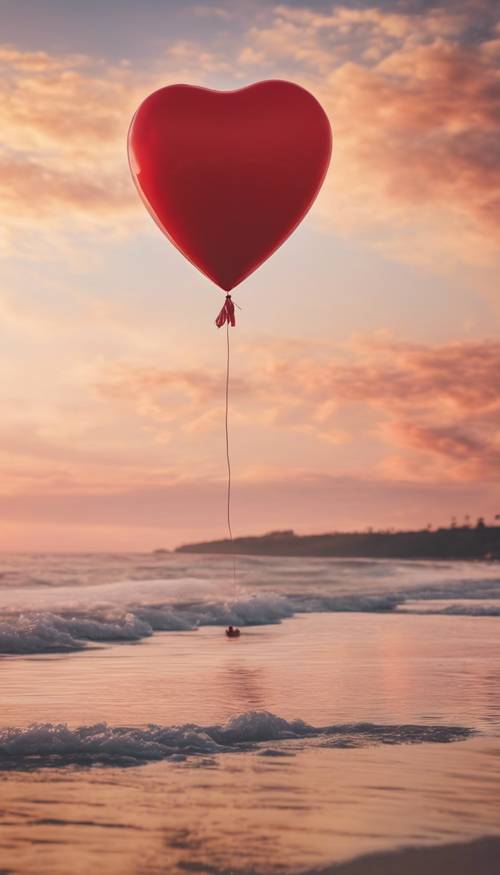 A red heart-shaped balloon floating over a serene beach during sunset.