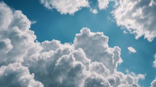 Immagine concettuale di nuvole bianche ariose strutturate che formano un motivo contro il cielo blu brillante.