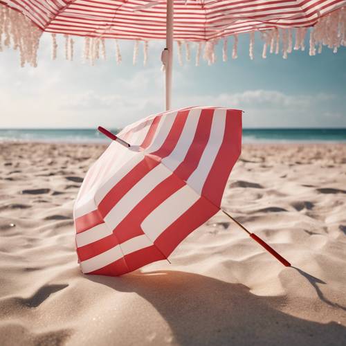 Пляжный зонтик в пастельно-красно-белую полоску.