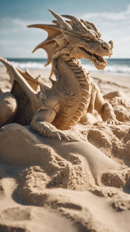 Дракон из песка, вылепленный на солнечном пляже, за ним разбиваются волны.