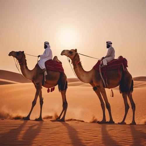 A beautiful camel caravan walking across the red sands of a Dubai desert at sunset.