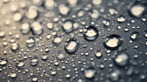 Regentropfen treffen auf eine flache, graue geometrische Oberfläche und erzeugen Wellen.