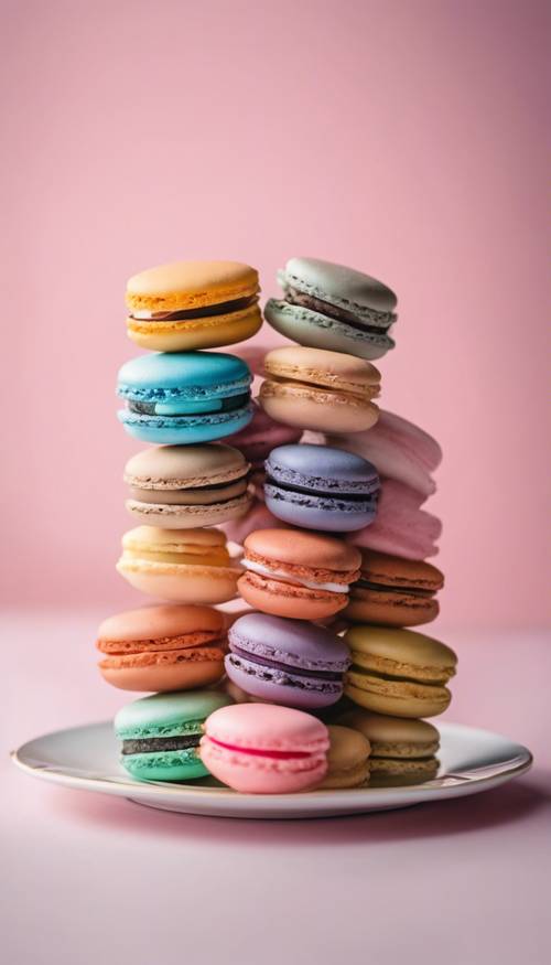 An assortment of colorful macaroons on a white porcelain plate with an airy pink blush-colored background.