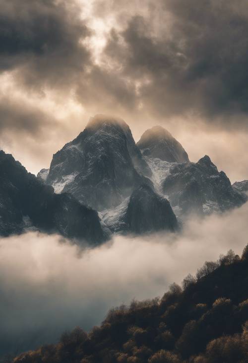 A dreamy recreation of rays of sun peaking through the heavy clouds over a rugged mountain range.