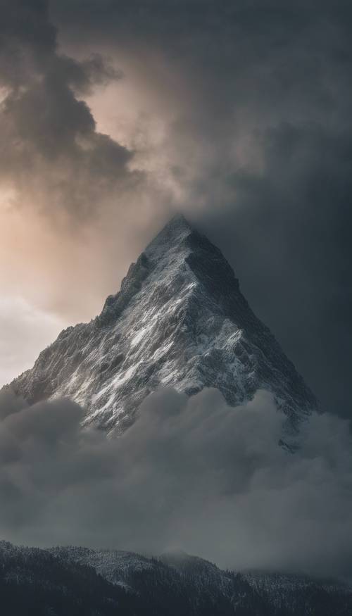 A mountain peak dramatically surrounded by roiling storm clouds.