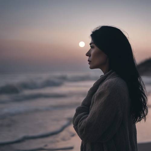 Uma mulher misteriosa com cabelos pretos grisalhos contemplando uma praia enluarada.
