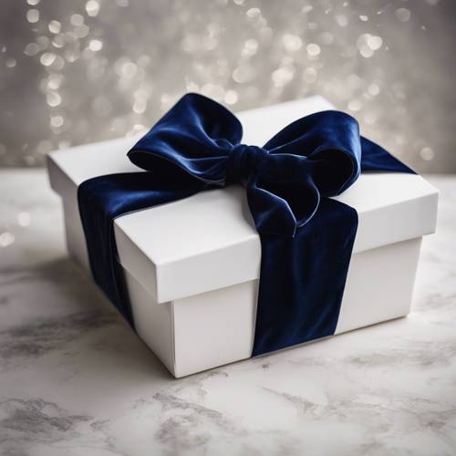 Un grande fiocco di velluto blu scuro sopra una scatola regalo bianca.