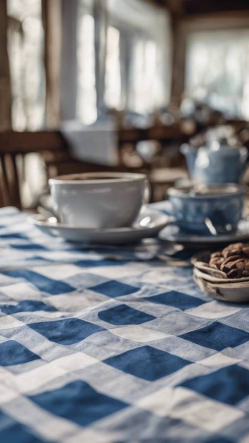 Uma toalha de mesa rústica xadrez azul e branca adornando uma velha mesa de madeira.