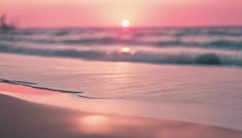 Pantai berpasir putih dengan matahari terbit berwarna merah muda di kejauhan.