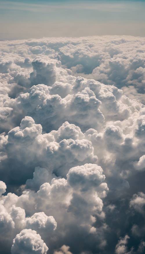 Vue aérienne d’une épaisse couverture de cumulonimbus s’étendant à perte de vue, rappelant un monde au-dessus du sol.