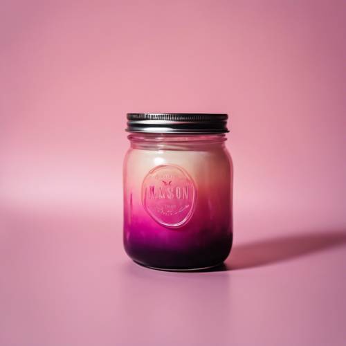 Uma vela em frasco de vidro com cera ombre rosa, a parte superior é escura com a cor desbotando na parte inferior.