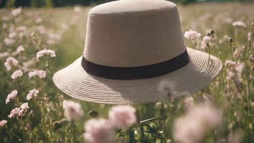 A wind-swept view of a gardener’s hat made of sturdy linen fabric in a flowering field.