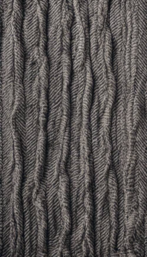 Um padrão de espinha de peixe cinza trançado em um lenço de caxemira macio.