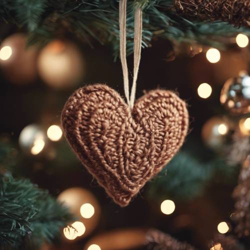 A brown, woolen heart-shaped decoration hanging on a Christmas tree.