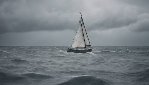 A sailing boat bobbing on a choppy sea on a grey, cloudy day.