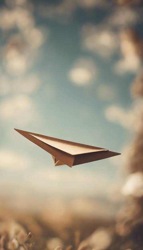 Un aeroplano di carta marrone in volo contro un cielo azzurro.