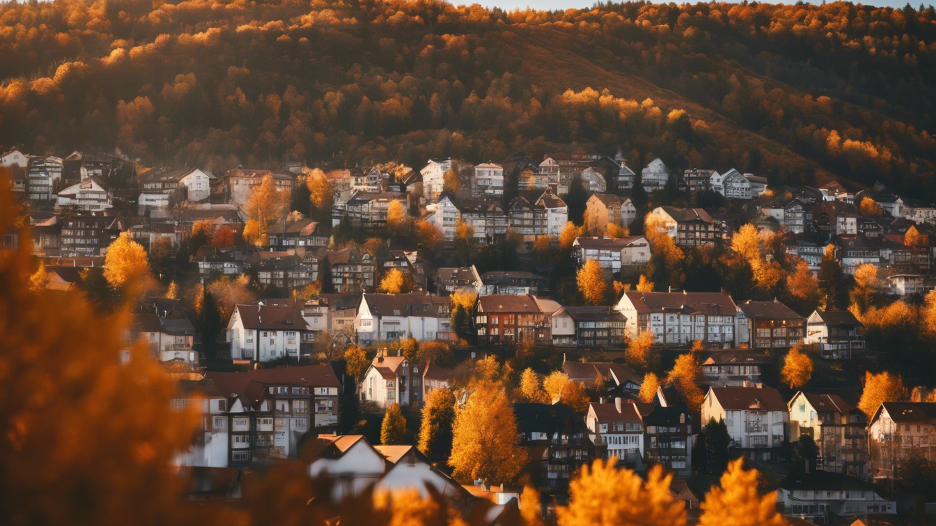 A calm skyline view of a mountain town in autumn, dappled in hues of orange and gold. Behang[cb2d4b5eada64efeb989]